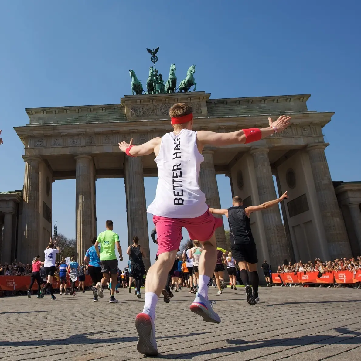 A runner cheers and celebrates as they cross the finish line of the Berlin Half Marathon