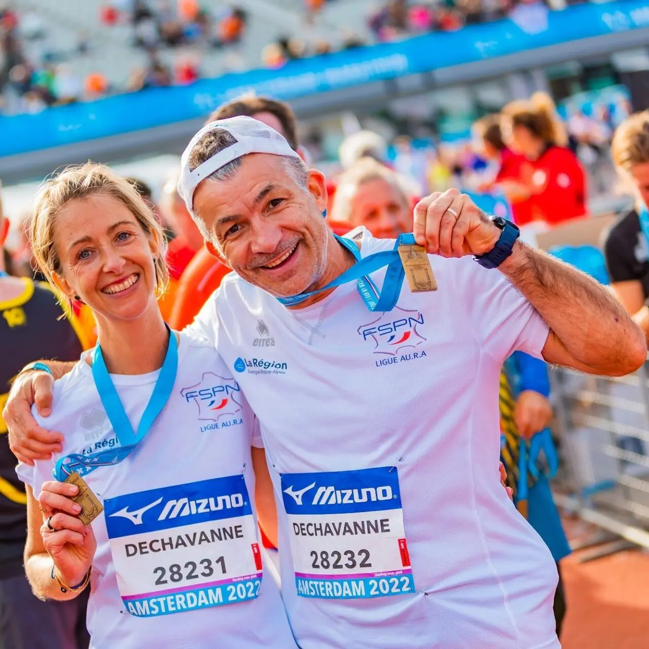 Two runners celebrate as they show off their medals at the end of the Amsterdam Marathon