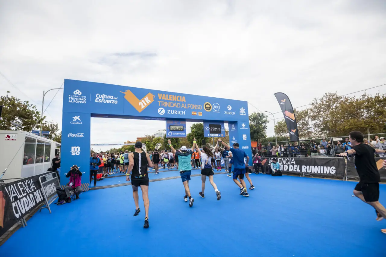 Runners embrace as they cross the finish line of the Valencia Marathon