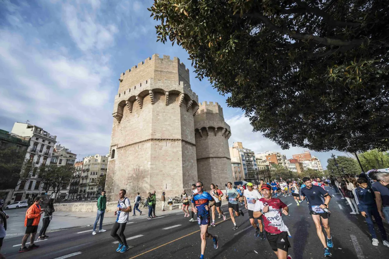 Runners passing along the streets past an historic monument in Valencia during the Valencia Marathon